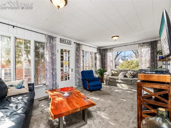 a living room with furniture a chandelier and a large window