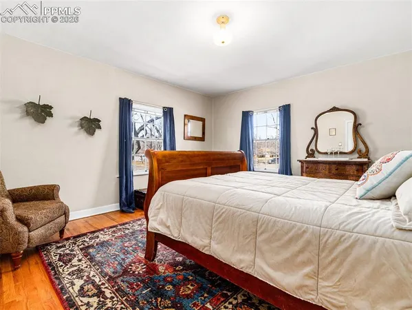 a bedroom with a bed and dresser with rug
