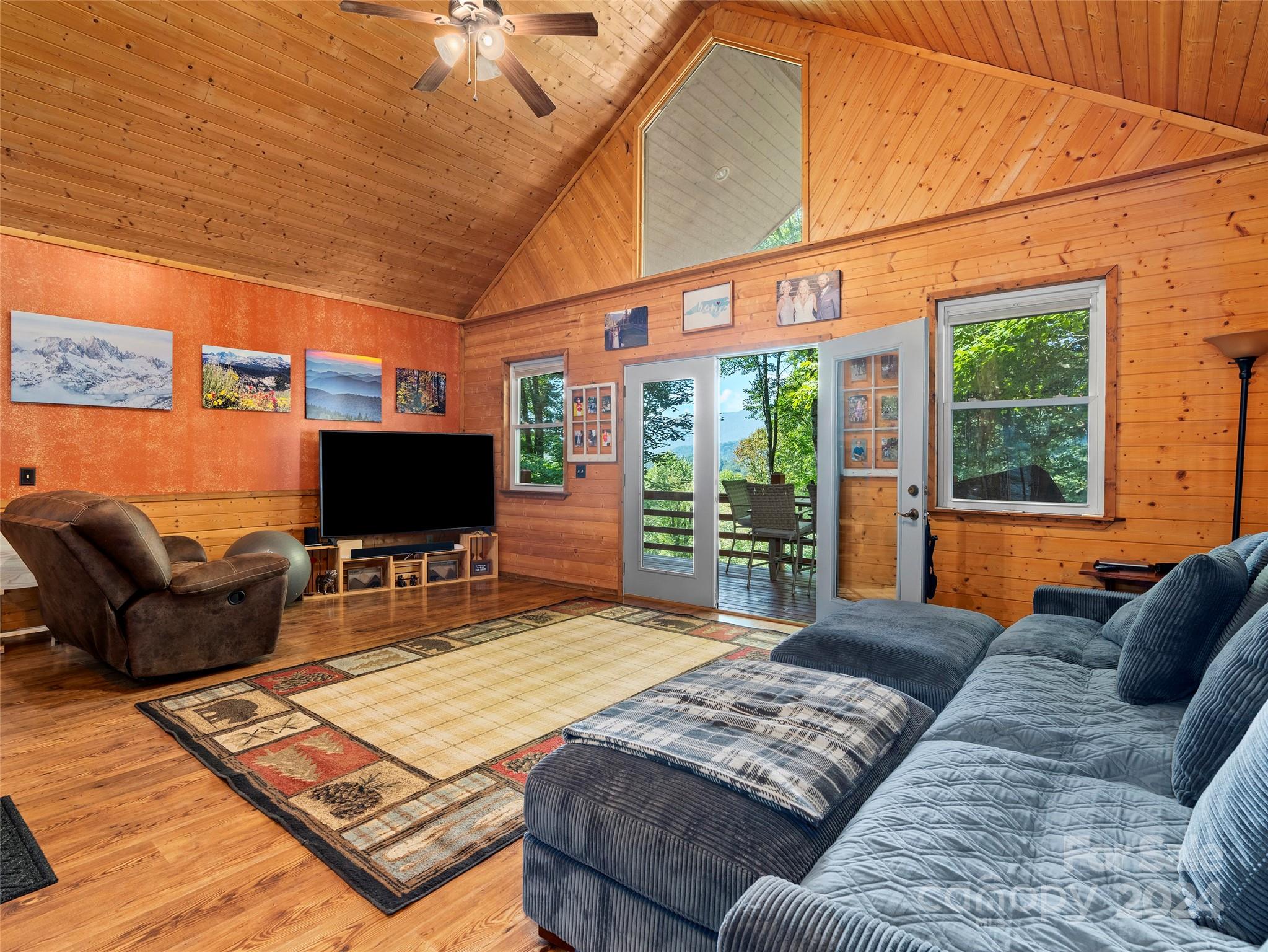 25 Dawn Valley Road Waynesville, NC 28785 - Photo 12 of 46 a living room with furniture a flat screen tv and floor to ceiling window
