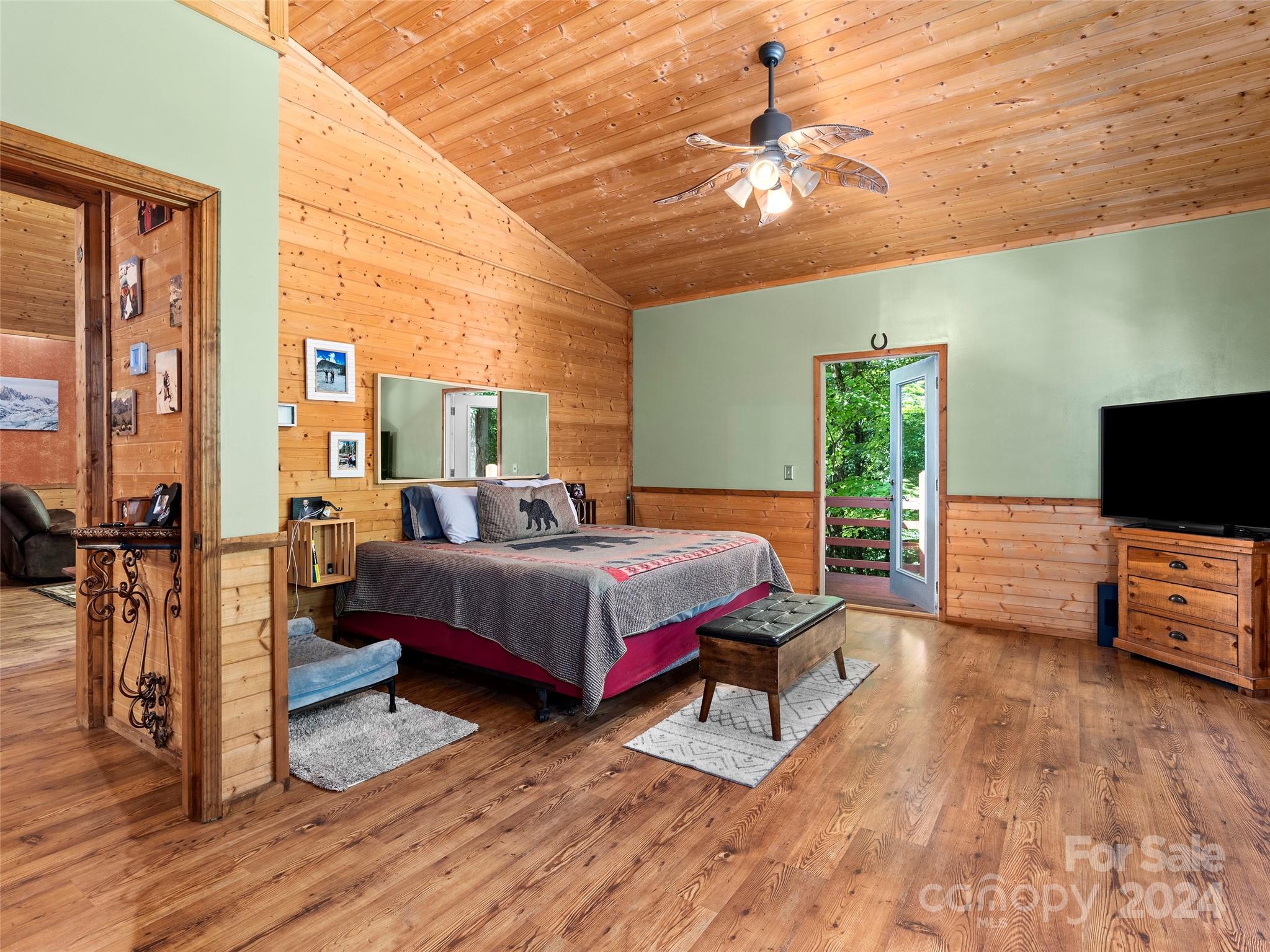 25 Dawn Valley Road Waynesville, NC 28785 - Photo 14 of 46 a bedroom with a bed and a chandelier
