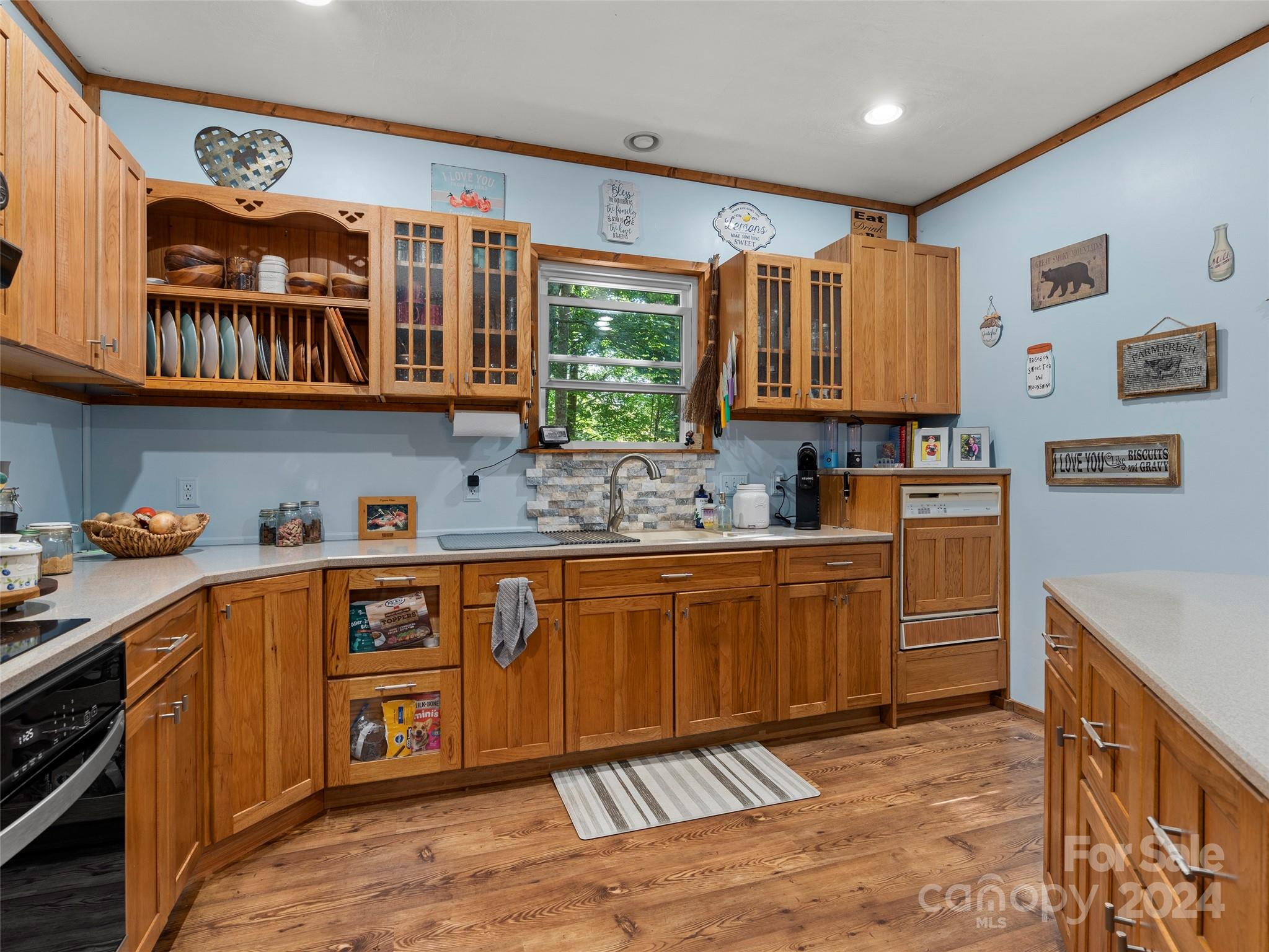 25 Dawn Valley Road Waynesville, NC 28785 - Photo 8 of 46 a kitchen with stainless steel appliances granite countertop a sink stove cabinets and wooden floor