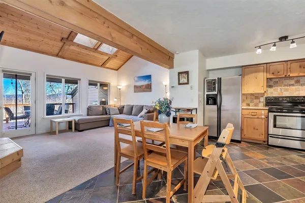 a dining room with furniture and kitchen view
