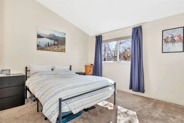 a bedroom with a bed and a painting on the wall