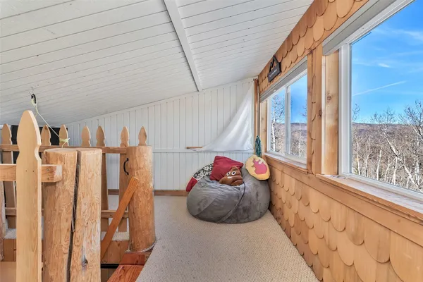 a balcony with wooden floor table and chairs