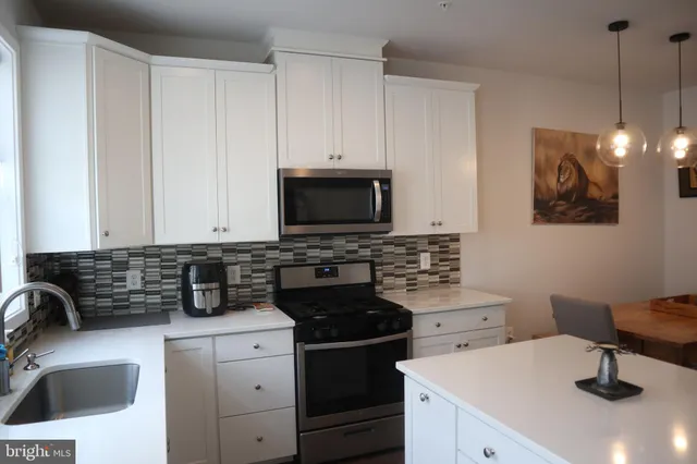 a kitchen with a sink a stove and a microwave