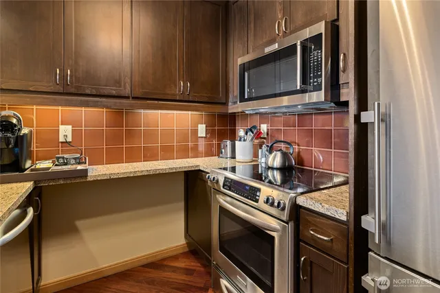 a kitchen with stainless steel appliances a stove a microwave and sink