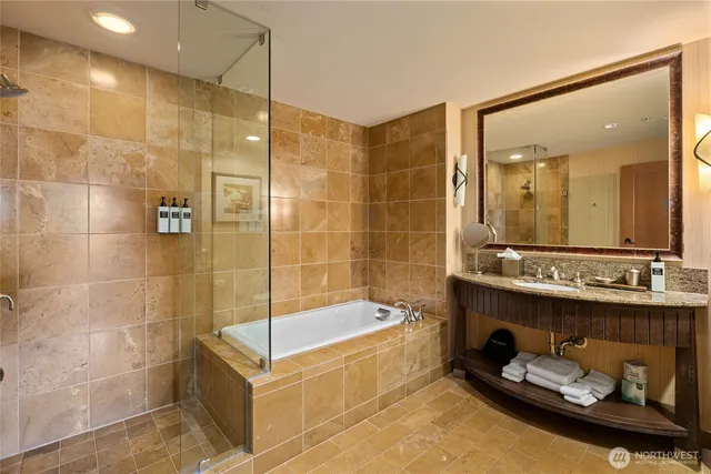 a bathroom with a tub a sink and shower