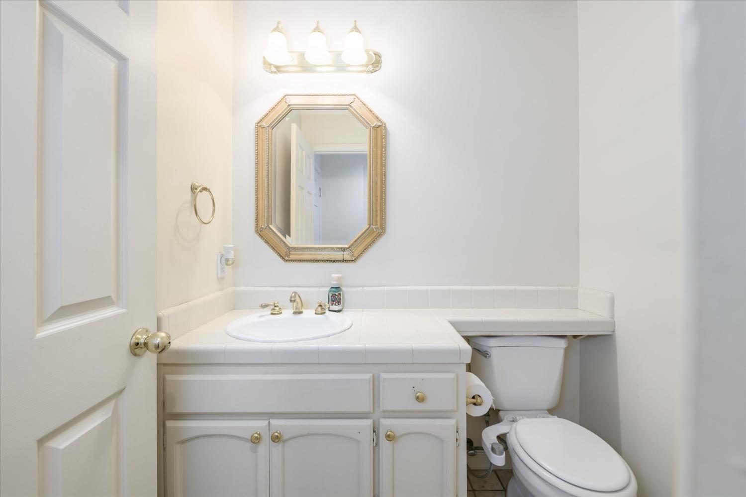 5636 Darby Road Rocklin, CA 95765 - Photo 12 of 29 a bathroom with a toilet sink vanity and mirror