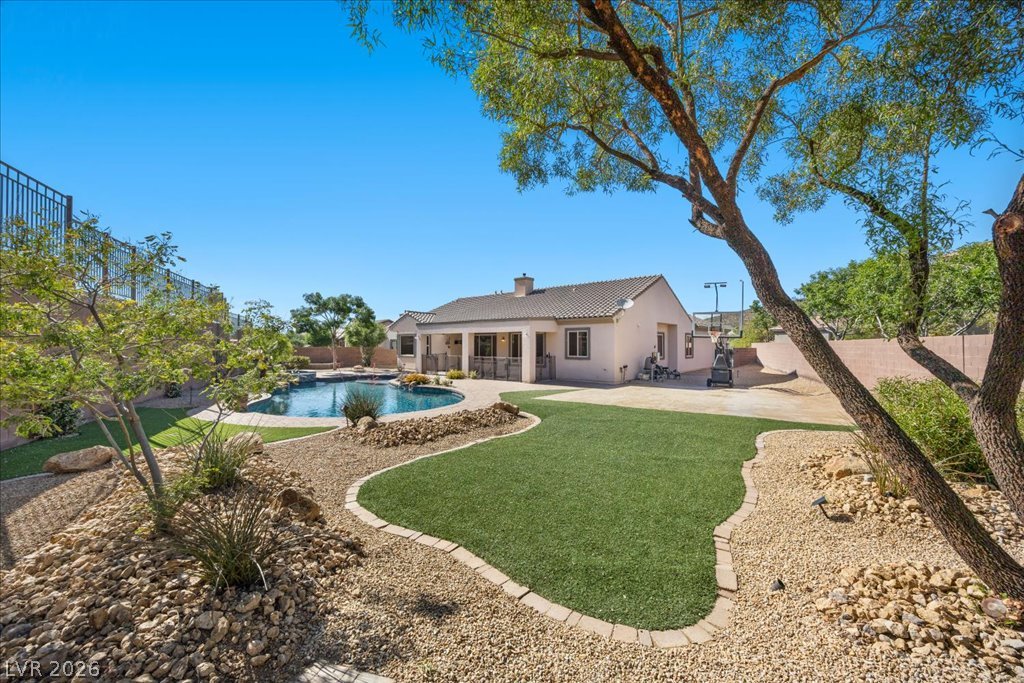 2125 De Rouge Avenue Henderson, NV 89044 - Photo 83 of 96 An inviting backyard oasis awaits with a sparkling pool and low-maintenance landscaping.
