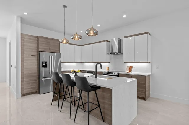 a kitchen with stainless steel appliances kitchen island a chandelier