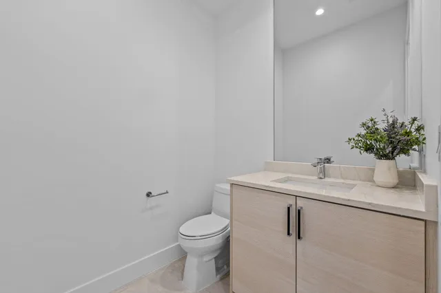 a bathroom with a granite countertop toilet sink and mirror