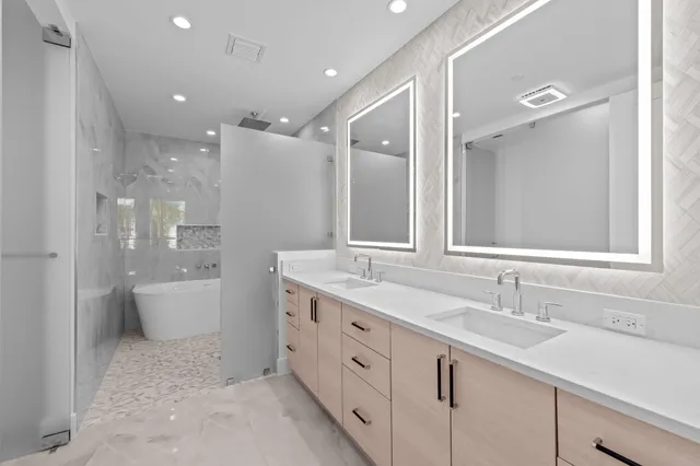 a bathroom with a double vanity sink and mirror with toilet