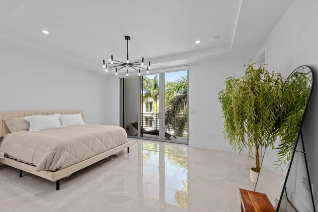 a bedroom with a large bed and a chandelier