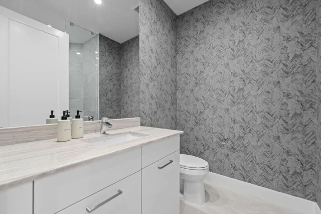 a bathroom with a sink a toilet and a mirror