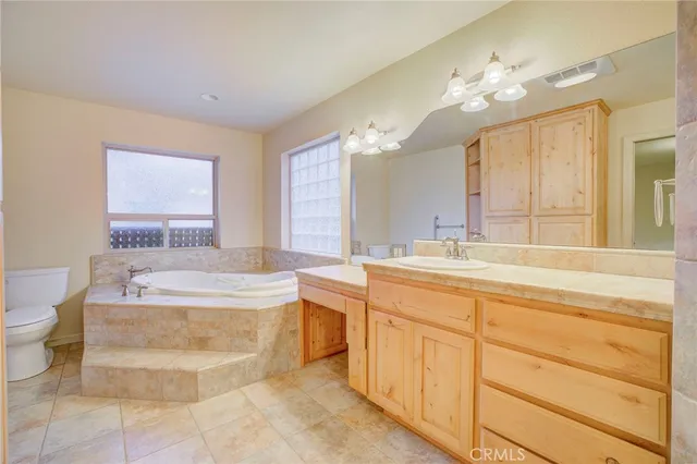 a spacious bathroom with a tub sink and mirror