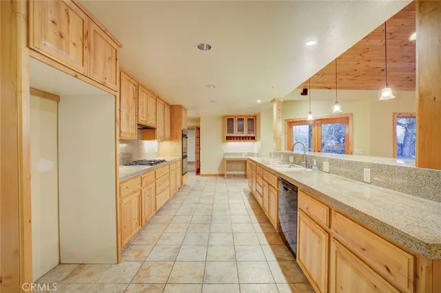 a large kitchen with stainless steel appliances kitchen island granite countertop a large counter top a sink and a refrigerator