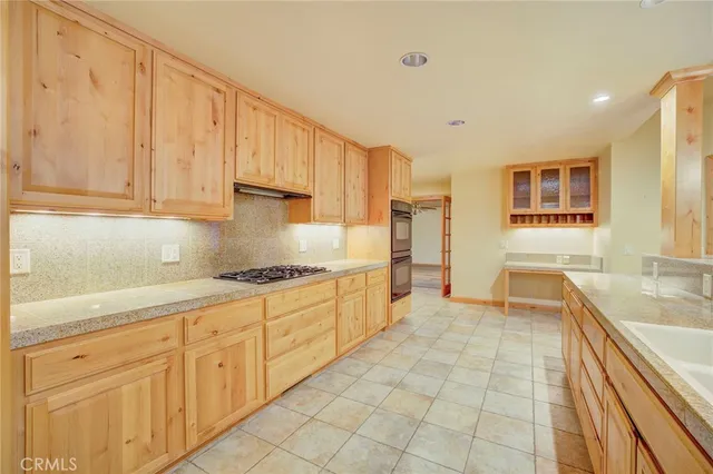 a large kitchen with stainless steel appliances granite countertop a sink and cabinets