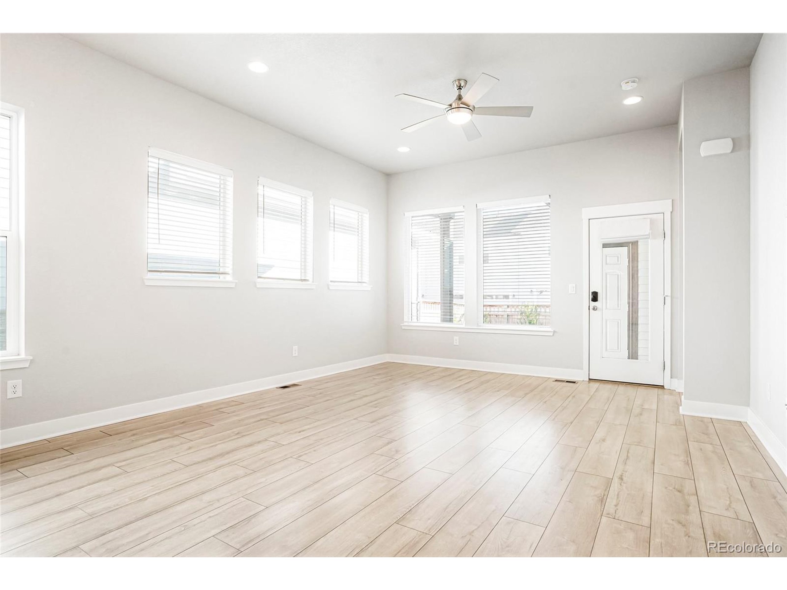 20968 East 60th Place Aurora, CO 80019 - Photo 14 of 50 an empty room with wooden floor and windows