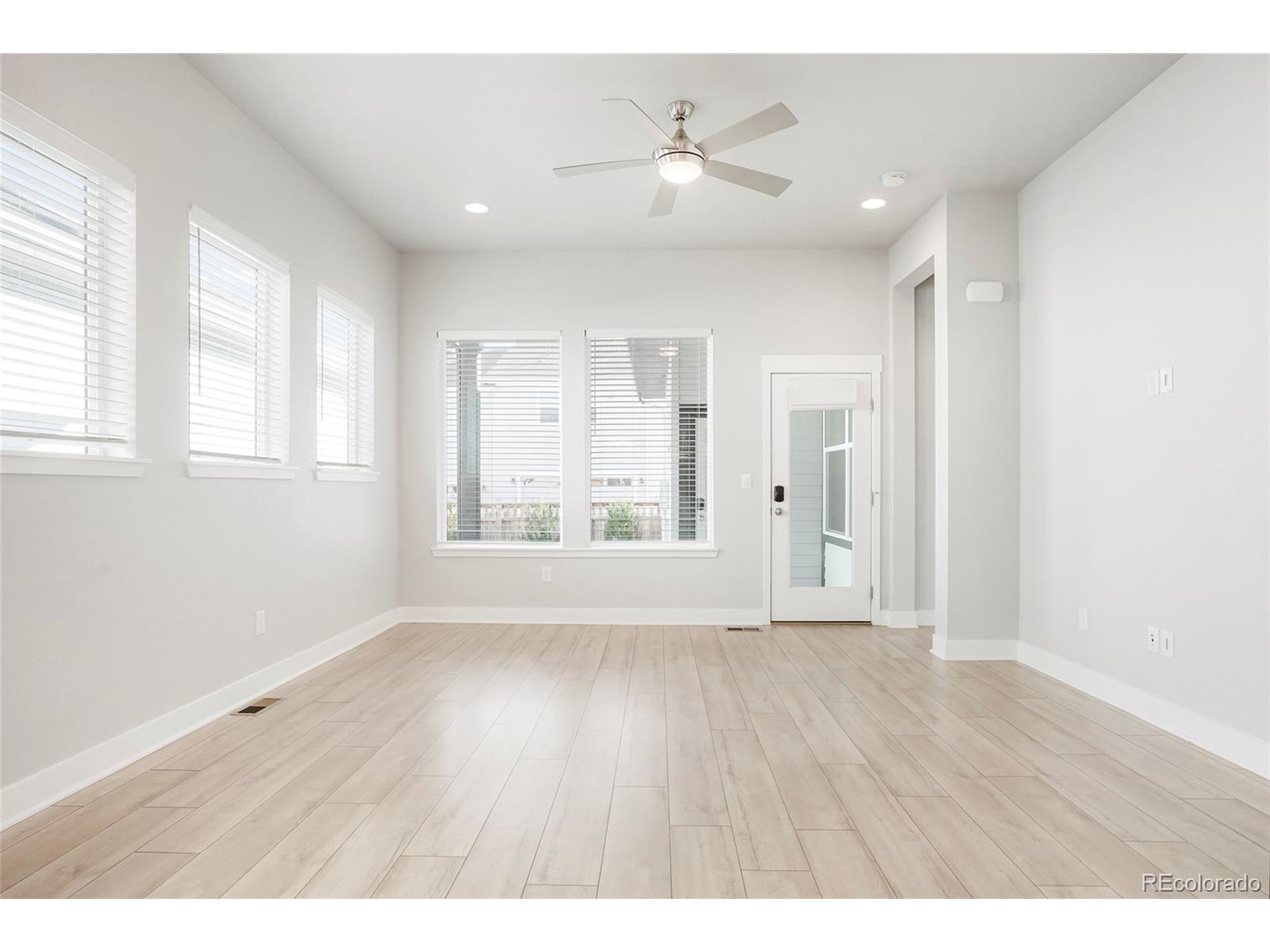 20968 East 60th Place Aurora, CO 80019 - Photo 16 of 50 a view of an empty room with a window and wooden floor