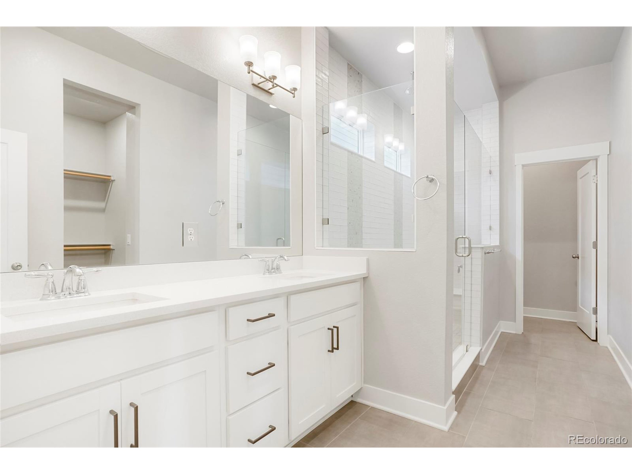 20968 East 60th Place Aurora, CO 80019 - Photo 24 of 50 a bathroom with a double vanity sink and mirror