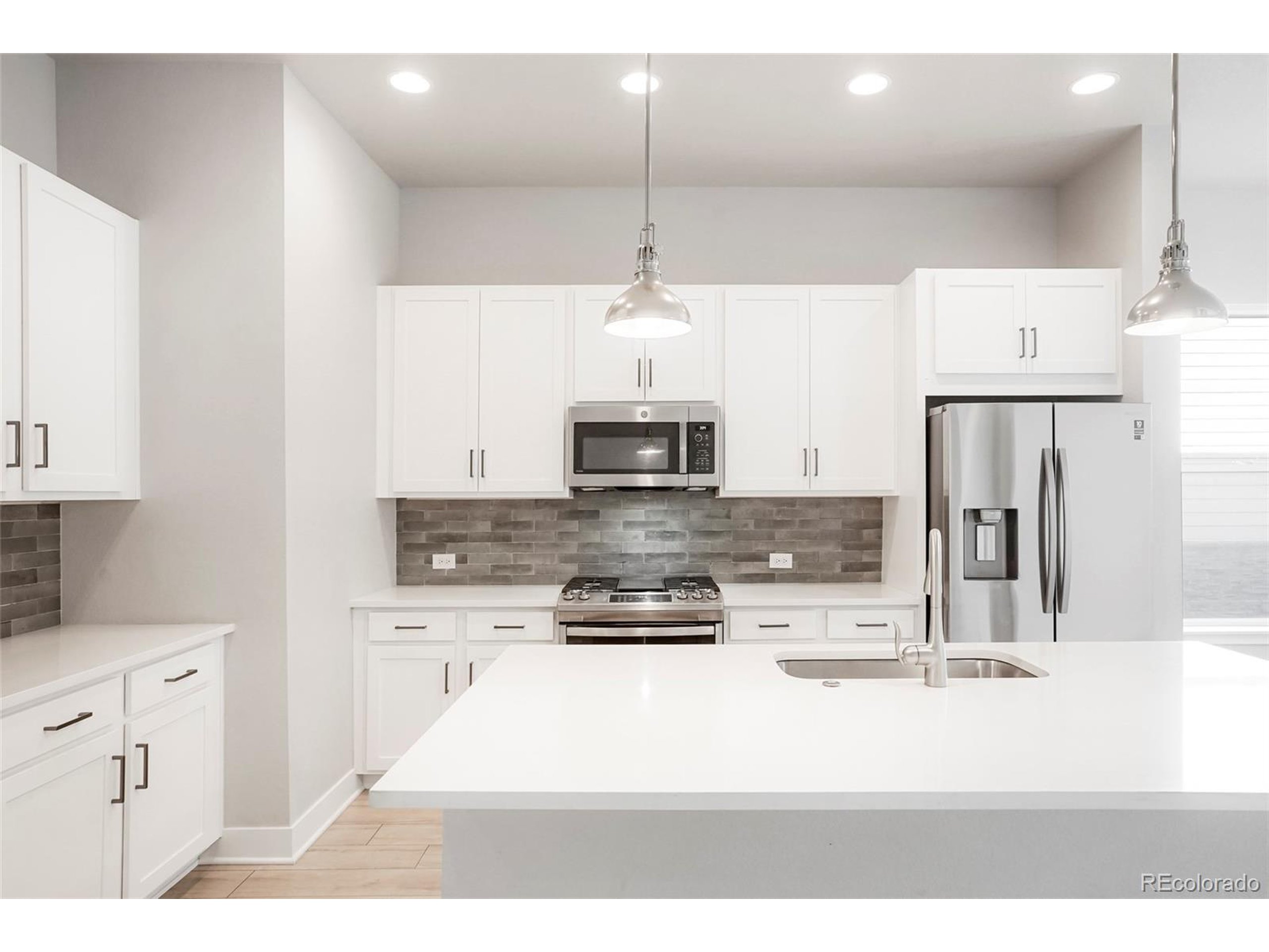 20968 East 60th Place Aurora, CO 80019 - Photo 3 of 50 a kitchen with kitchen island a counter top space appliances and cabinets