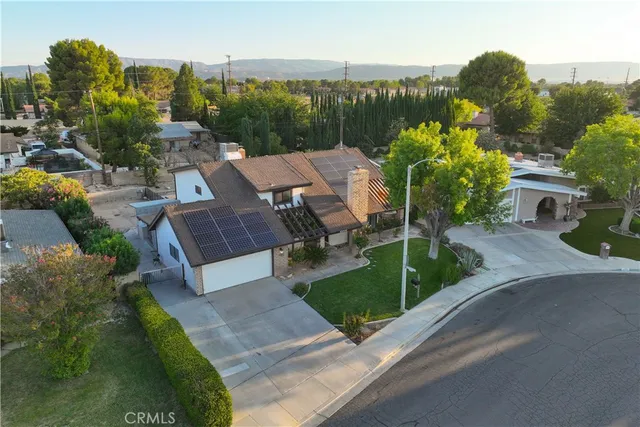 a view of a garden with plants and a bench with lake view