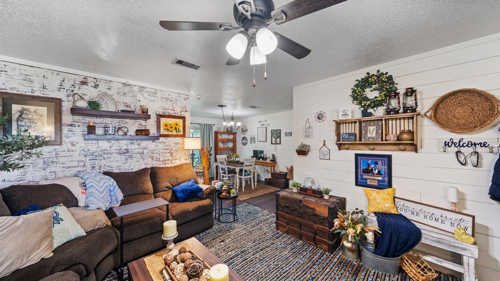230 Dodson Street Canton, TX 75103 - Photo 3 of 17 a living room with furniture a chandelier and a fireplace