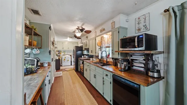 a kitchen with stainless steel appliances a stove top oven a sink a counter space and cabinets