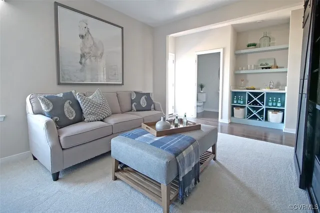 a living room with furniture and a painting on the wall