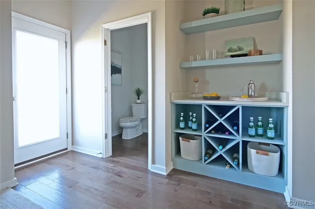 a view of an empty room with wooden floor and a cabinet
