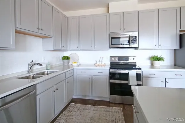 a kitchen with cabinets appliances a sink and a counter top space