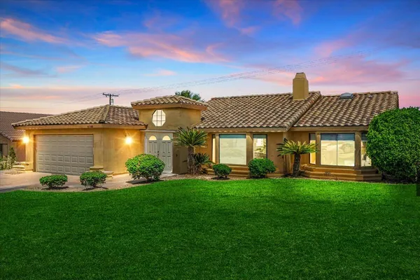 a front view of a house with a yard and lake view