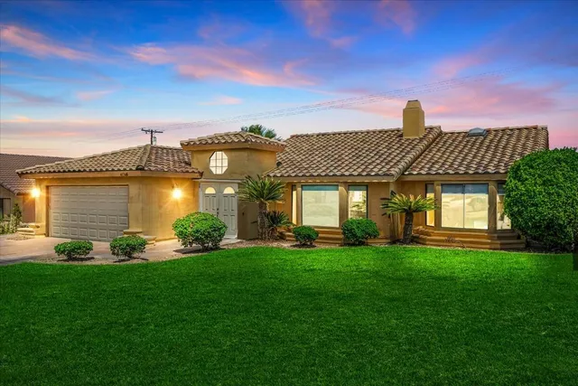 a front view of a house with a yard and lake view