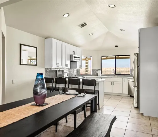 a kitchen with refrigerator a stove and chairs
