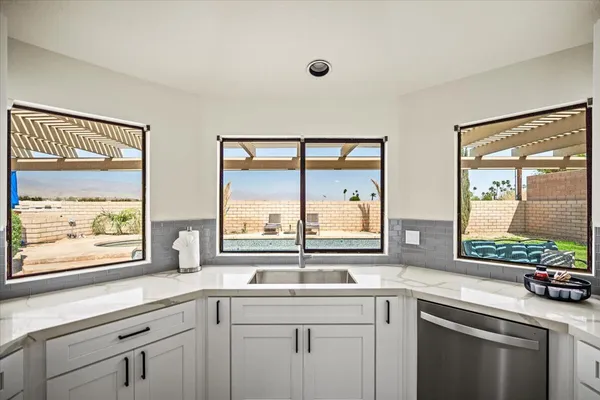 a kitchen with stainless steel appliances granite countertop a stove top oven a sink dishwasher and cabinets