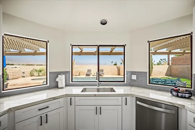 a kitchen with stainless steel appliances granite countertop a stove top oven a sink dishwasher and cabinets