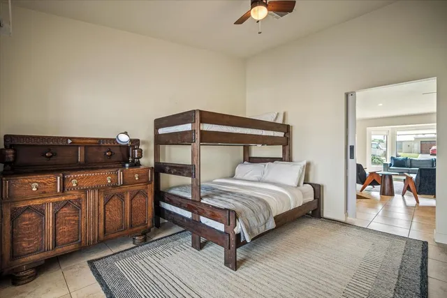 a bedroom with a bed a lamp on dresser and a window