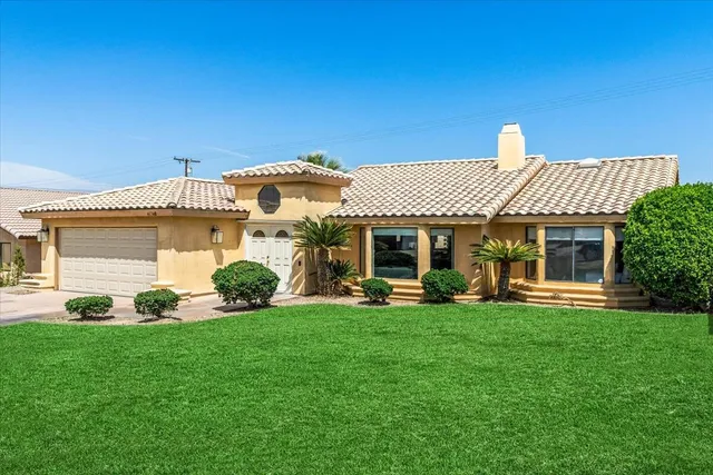 a front view of a house with a garden