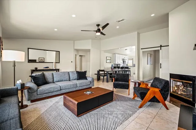 a living room with furniture a ceiling fan and a rug
