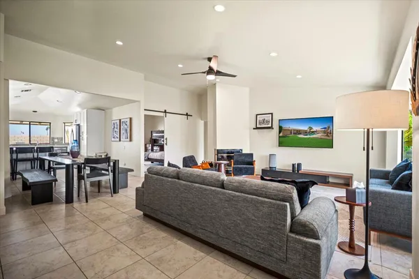 a living room with furniture a flat screen tv and kitchen view