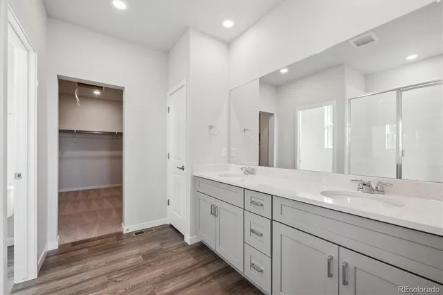 a spacious bathroom with a double vanity sink and mirror