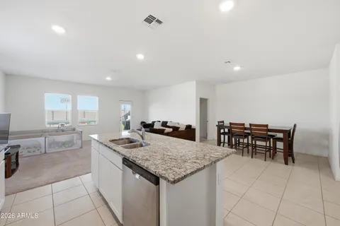 a kitchen with granite countertop sink table and chairs