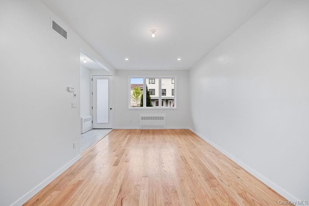 472 West Central Avenue, Unit 105 Spring Valley, NY 10977 - Photo 5 of 22 an empty room with wooden floor and windows