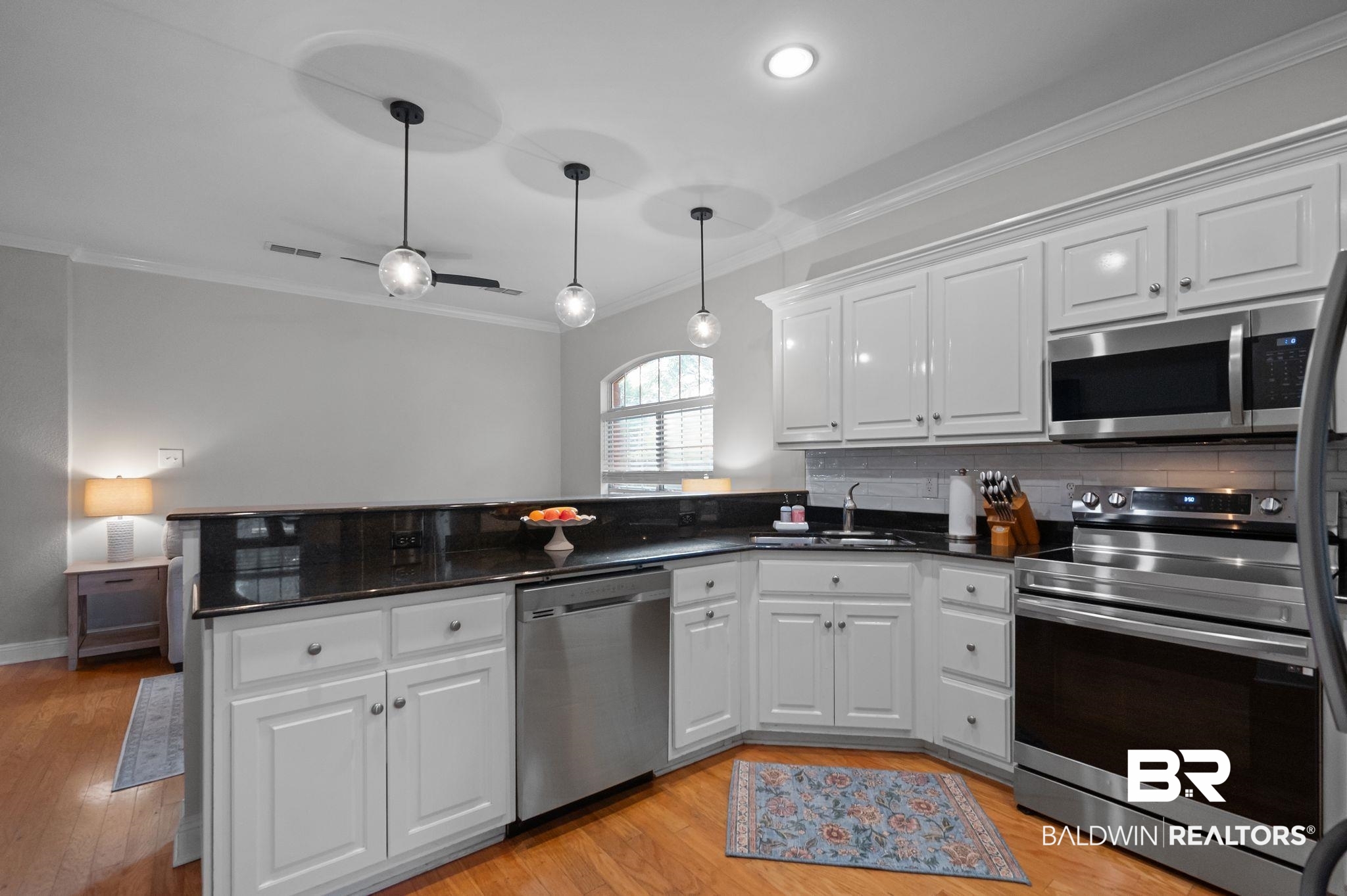 1825 Spring Hill Avenue Mobile, AL 36607 - Photo 12 of 43 Kitchen featuring stainless steel appliances, white cabinetry, crown molding, dark stone countertops, and hanging light fixtures