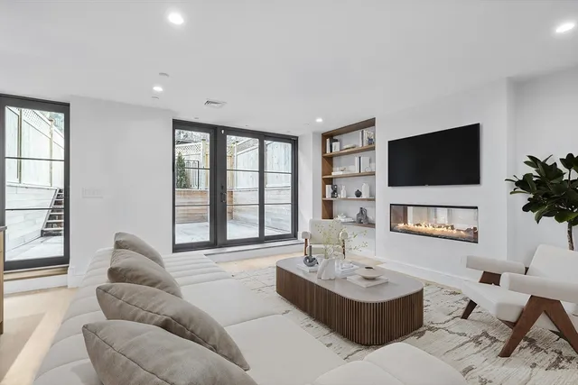 a living room with furniture a fireplace and a flat screen tv
