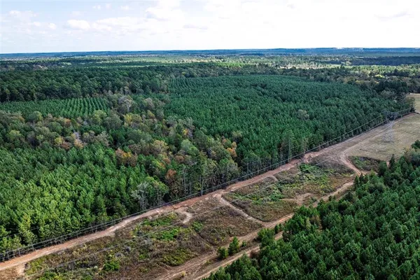 an aerial view of residential houses with outdoor space and trees