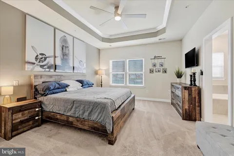 a bedroom with a bed a flat screen tv and a large window with the outer view