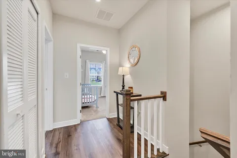 a view of a hallway with wooden floor and staircase