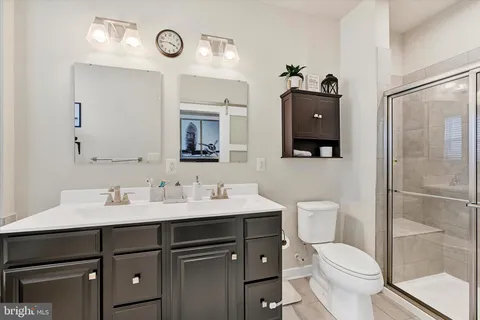 a bathroom with a toilet sink vanity and mirror
