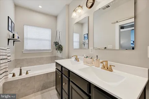 a bathroom with a tub sink and mirror